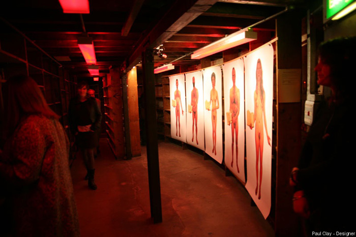 Paul Clay's Set Design, Lighting Design, and Video Design, for National Theatre Wales, Volcano Theatre, Welsh National Opera's co-production entitled Shelf Life at the Old Swansea Library, Wales, UK - near life sized nude portraits of the actors as librarian/saints, basement.